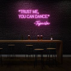 there is a neon sign that says trust me, you can dance tequila on the wall