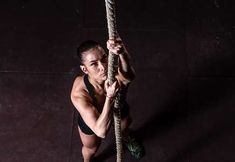 a woman is holding on to a rope with one hand and looking at the camera