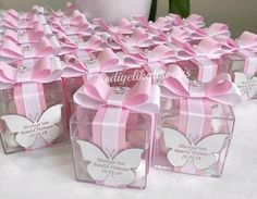 small clear boxes with pink bows and butterflies on the top are sitting on a table