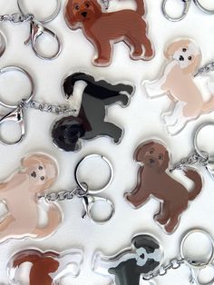 a bunch of key chains that have different colored dogs on them and one is black, the other has brown