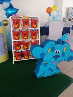 there is a blue elephant in the middle of a party table with balloons and decorations