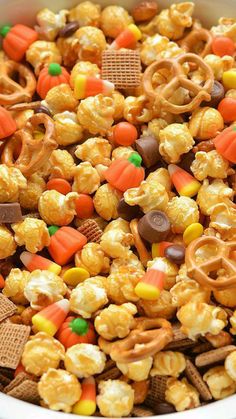 a white bowl filled with candy corn and pretzels