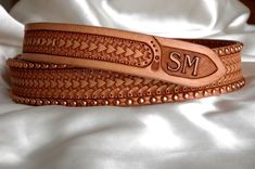 a leather belt with the initials sm on it