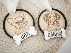 two wooden ornament with dogs on them, one is for ajax and the other is for oakley