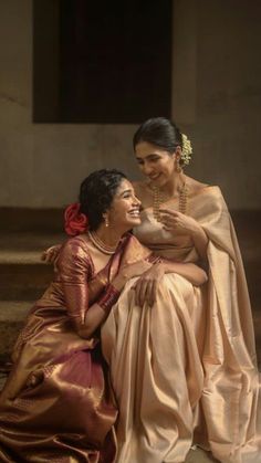 two women sitting next to each other on steps