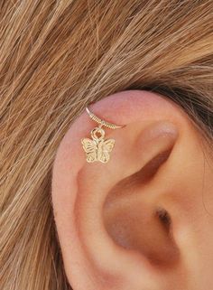 a woman's ear with a gold butterfly on it