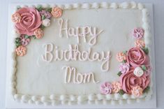 a birthday cake decorated with pink flowers and the words happy birthday mom written on it