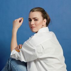 a woman in white shirt sitting on chair with pencil