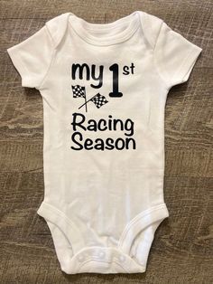 My 1st Racing Season This listing is for one (1) white bodysuit  with black lettering on the front. Available in short sleeve.  Available Sizes:  Newborn 3 Month 6 Month  9 Month  12 Month I hand make each bodysuit, no two will be exactly the same, please allow 3-7 business days for production. Please email me with any questions.  Material: White 100% Cotton  Care Instruction: Inside out wash Tumble Dry Do not bleach Do not iron directly onto the design Do not dry clean Want to see more, check u White Short Sleeve Bodysuit With Graphic Print, White Cotton Sports Bodysuit, Fitted White Bodysuit With Letter Print, Fitted White Onesie With Graphic Print, Casual Short Sleeve Bodysuit For Sports, Casual Short Sleeve Sports Bodysuit, White Casual Bodysuit For Sports, White Casual Sports Bodysuit, White Fitted Onesie With Graphic Print