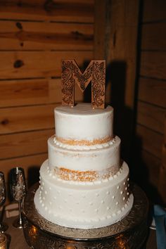 a wedding cake with the letter m on top