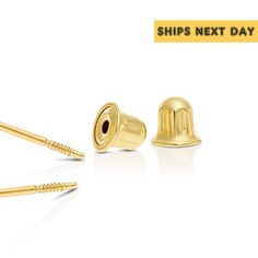 two gold ear plugs with screws in the middle and one on each side