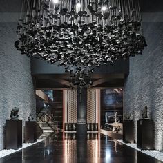 a large chandelier hanging from the ceiling in a room with black and white walls