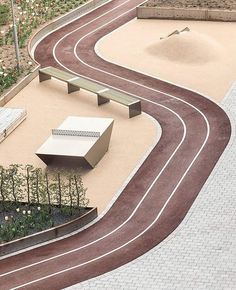 an aerial view of a track with benches and flowers