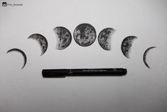 three phases of the moon drawn on paper with a black pen next to it,