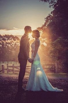 a bride and groom standing in front of the sun