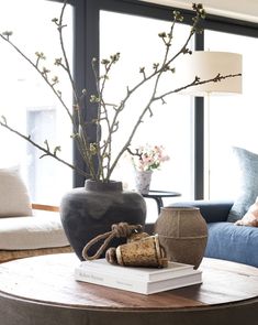 a living room filled with furniture and a vase on top of a wooden coffee table