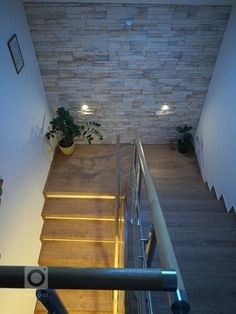 an overhead view of a stair case with lights on and plants in potted planters