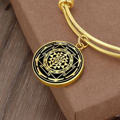 "This Sri Yantra Bracelet Is the Perfect Gift Whether for Yourself or a Loved One.  Explore all our sacred geometry jewelry here: https://www.etsy.com/in-en/shop/SymbolicPresent?ref=simple-shop-header-name&listing_id=877238359§ion_id=22613481 ➜ Our jewelry is made of high-quality surgical steel with a shatterproof liquid glass coating and an 18k gold finish option. ➜ Engrave onto the back of the Sri Yantra pendant your loved one's name, your wedding date, an anniversary, or anything else you wan Amulet Style Bracelet Jewelry Gift, Spiritual Bangle Jewelry Gift, Amulet Bracelet Jewelry As Gift, Amulet Bracelet Jewelry Gift, Gold Geometric Bracelet For Gift, 14k Gold Spiritual Necklaces For Meditation, Symbolic Meditation Bracelet Jewelry, Spiritual Compass Design Jewelry Gift, Spiritual 22k Gold Pendant Necklace