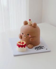 a cake shaped like a teddy bear with a birthday hat on