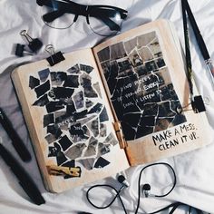 an open book with writing on it next to headphones and other items that include eyeglasses