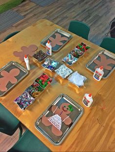 a wooden table topped with lots of trays filled with different types of food and decorations