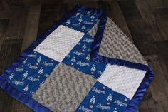 two baby quilts are laying on the floor next to each other, one is blue and gray