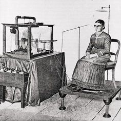 a woman sitting in a chair next to an old fashioned machine