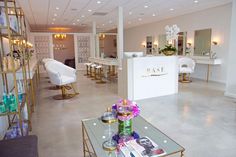 the interior of a salon with chairs, tables and flowers in vases on display