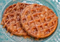 two waffles covered in caramel sauce on a blue plate