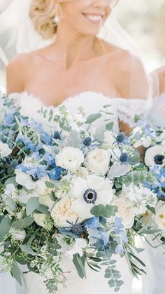 a bride holding a bouquet of white and blue flowers