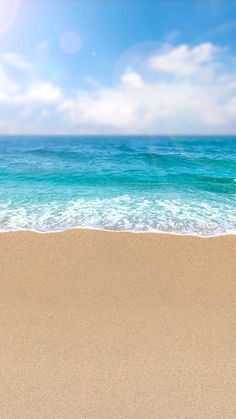 an empty sandy beach with blue water and white clouds in the background, under a partly cloudy sky