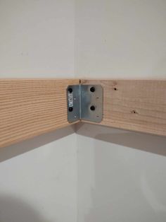 a piece of wood that is attached to a wall with a metal latch on it