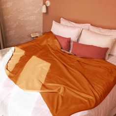 a bed with an orange blanket on top of it