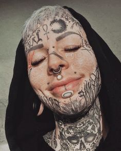 a man with tattoos and piercings on his face