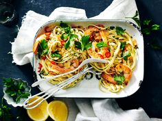 a plate of pasta with shrimp and parsley