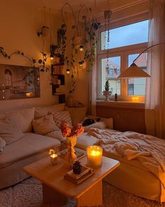 a living room filled with lots of furniture next to a window covered in plants and candles