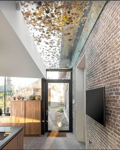 an open kitchen area with brick walls and flooring, along with a flat screen tv mounted on the wall