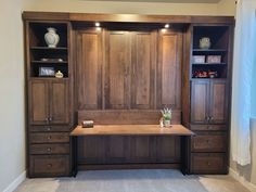 a large wooden desk sitting in the middle of a room with built - in bookshelves