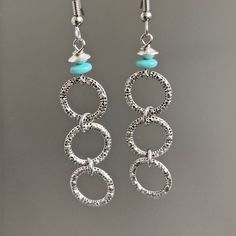 "Silver Hoop Earrings - Small connected Silver Pewter Hoops dangle from Turquoise Czech Glass Beads. The hoops have a pretty texture. Surgical Steel Earwires The hoops are 14mm in diameter (slightly over .5\") Earrings measure just over 2.75\" from top of earwires to bottom of beads." Turquoise Metal Hoop Earrings, Turquoise Dangle Hoop Earrings, Turquoise Hoop Metal Jewelry, Turquoise Metal Hoop Jewelry, Nickel-free Turquoise Metal Hoop Earrings, Turquoise Metal Jewelry With Ear Wire, Turquoise Metal Earrings For Pierced Ears, Turquoise Metal Round Hoop Earrings, Turquoise Metal Dangle Earrings