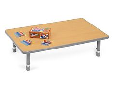 a wooden table topped with two boxes of candy on it's legs and a box of cereal on top of the table