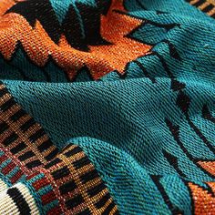 an orange, blue and black blanket with designs on it