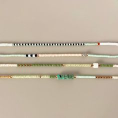 four different colored bracelets on a white surface