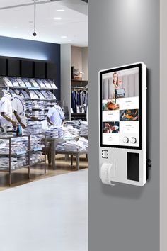 an electronic device is mounted to the wall in a clothing store, displaying images of men's shirts