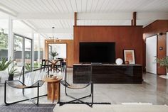 a living room filled with furniture and a flat screen tv on top of a wooden wall