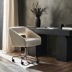 an office chair sitting in front of a desk with a vase on it and a book