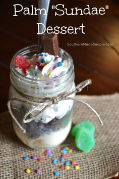 a jar filled with whipped cream and sprinkles on top of a table