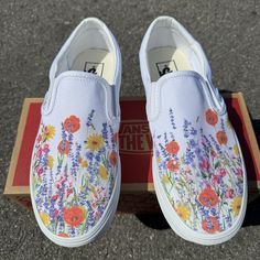 These shoes have a bohemian style field of wildflowers across the tops of the shoes.  We buy each pair of blank shoes BRAND NEW from the Vans retail store. The ink is permanent and will never come off. Made in the USA. This price includes everything: shoes, artwork, and shipping. Thanks for stopping by our Etsy shop! Please message us with any questions! Sizes listed are in US sizing scale. If you have any issues with your order, please feel free to reach out to us and we will be more than glad Vans Drawing On Shoes, Painting White Vans, Painted Vans Ideas, Shoe Painting Ideas Vans, Vans Embroidery Slip On, Painted Vans Slip On, Hand Painted Vans Slip On, Vans Floral Shoes, Hand Painted Slip-on Sneakers For Spring