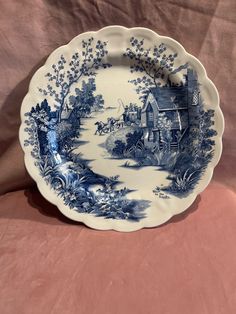 a blue and white plate sitting on top of a pink cloth covered tablecloths