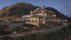 a large house sitting on top of a lush green hillside