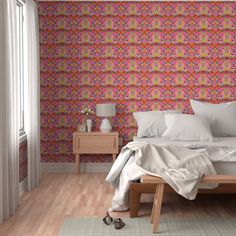 a bed sitting in a bedroom next to a wallpaper covered in colorful flowers and leaves